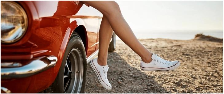 bequeme sneakers an einem roten auto am meer