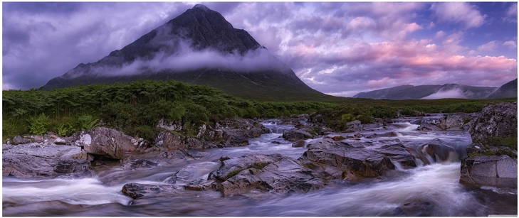 berglandschaft mit wasserlauf und nebel