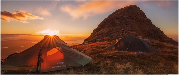 berglandschaft mit zelten im sonnenuntergang