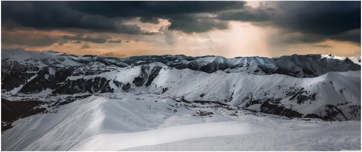 dramatische winterlandschaft mit schneebedeckten bergen und wolken