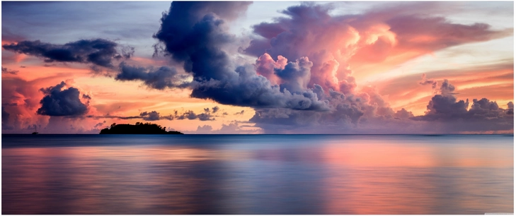dramatische wolkenformationen beim sonnenuntergang ueber ruhigem wasser