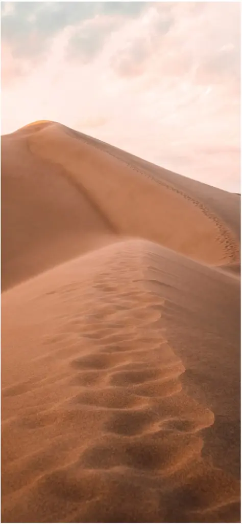duenenlandschaft im wuestensand mit fusspuren