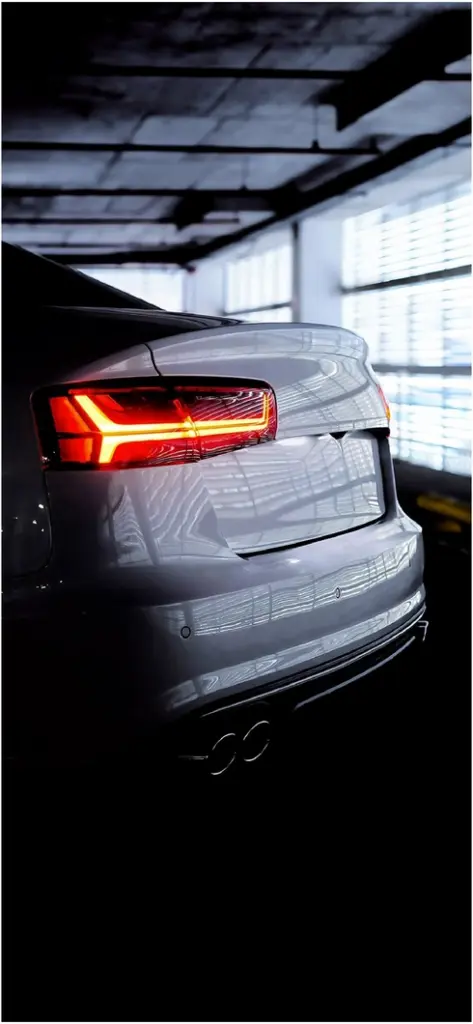 elegantes auto mit leuchtenden ruecklichtern in dunkler garage