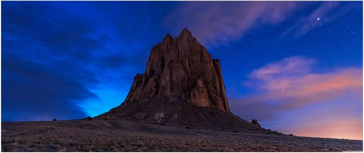 felsformation shiprock in new mexico bei daemmerung