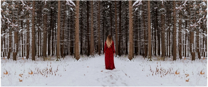 frau im roten kleid im verschneiten wald
