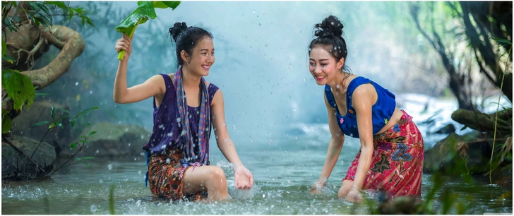 froehliche frauen im wasser zwischen ueppiger natur