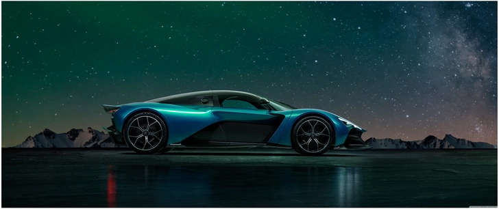 futuristisches sportauto vor sternenhimmel und bergen