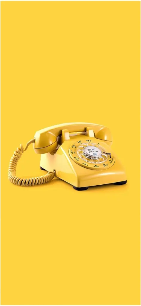 gelbes retro telefon einfarbiger hintergrund
