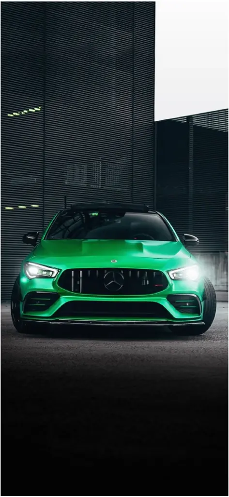 gruener mercedes vor moderner gebaudeoberflaeche