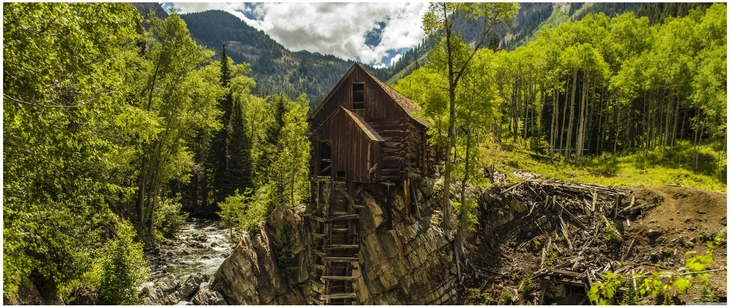 historisches holzhaus in der natur mit fluss und bergen