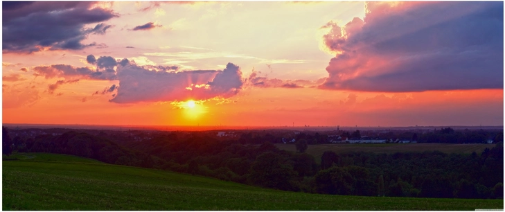 lebendiger sonnenuntergang ueber malerischer landschaft