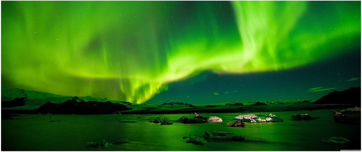 leuchtende nordlichter ueber einer ruhigen wasserflaeche