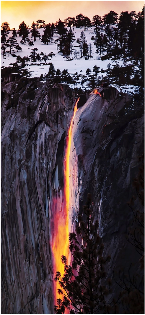 leuchtender-wasserfall-im-abendlicht-ueber-schneebedeckten-bergen