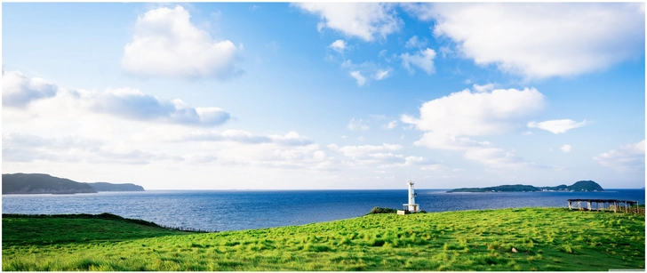 leuchtturm an der kueste mit weitem blick ueber das meer