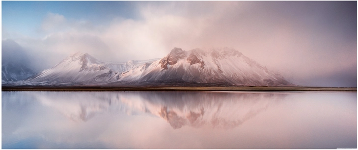 majesitaetische islandische berge mit wolken und spiegelung