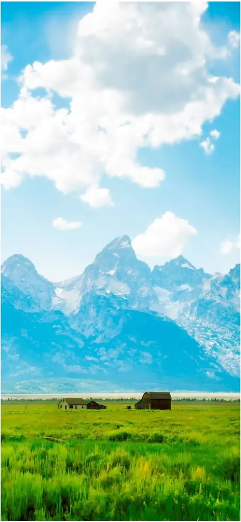 majestatische berge und gruene wiesen mit haeusern