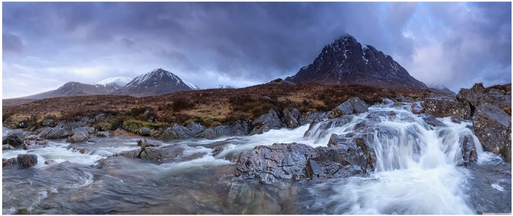 majestetische berglanschaft mit wasserfall und dunklen wolken