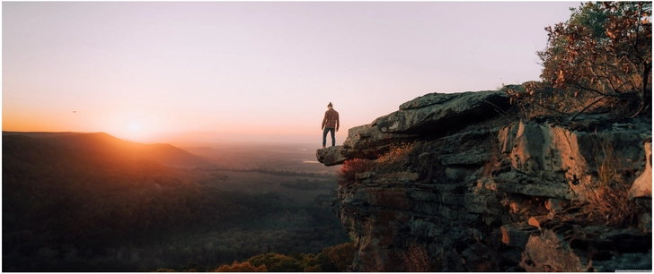 mensch auf felsformation bei sonnenuntergang in der natur