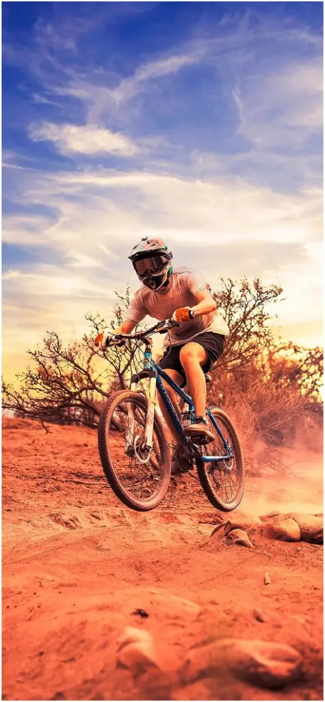 mountainbiker in der wueste bei sonnenuntergang