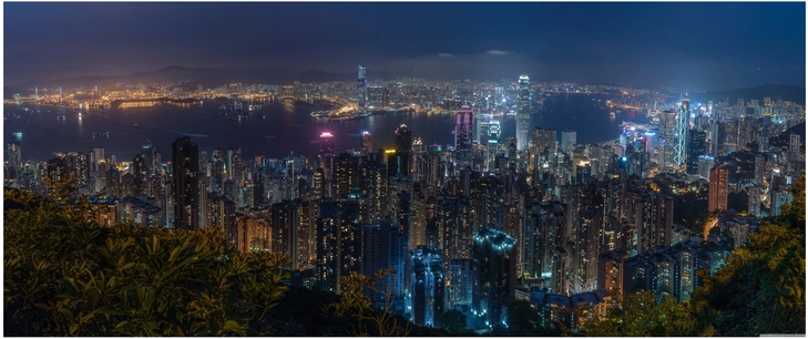 nachtansicht der skyline von hongkong mit lichtern und bergen