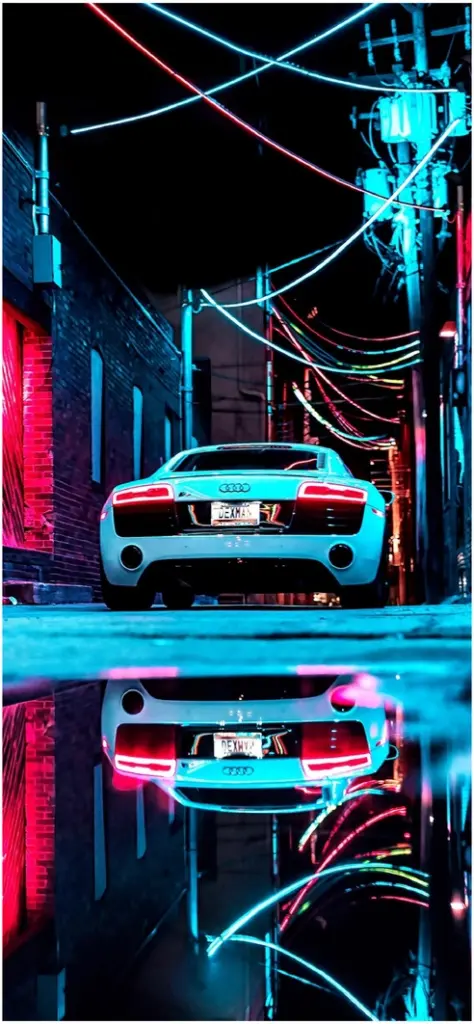 neonbeleuchtete stadt mit audi r8 in der gasse