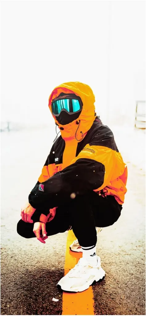 person im leuchtend orangefarbenen outfit in winterlicher umgebung