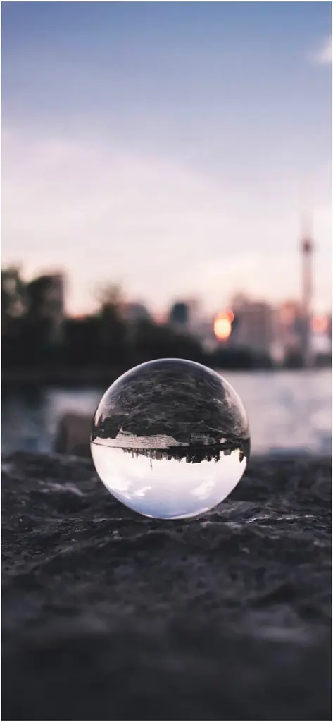 reflexion einer stadtlandschaft in einer glasklaren kugel