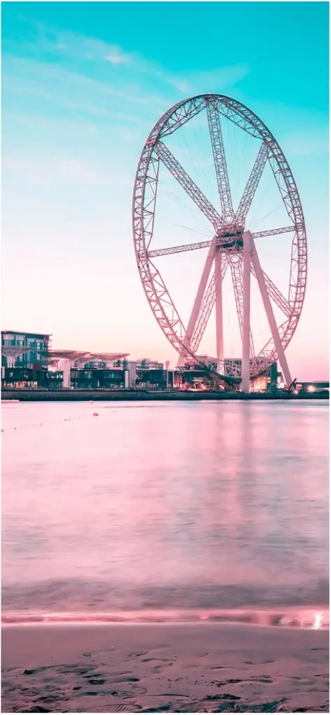riesenrad am ruhigen gewaesser in pastellfarben