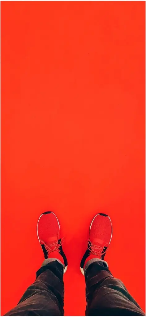 rote sportschuhe auf rotem boden