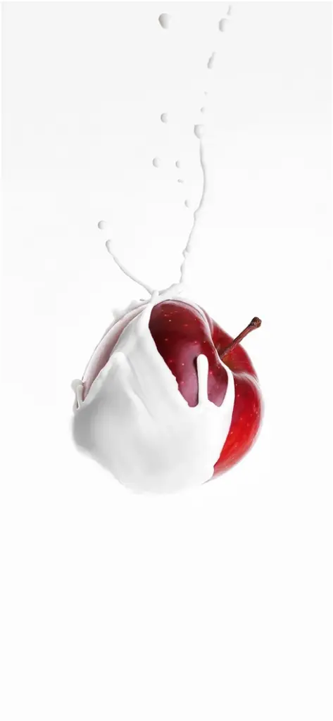 roter apfel in weisser fluessigkeit mit spritzern
