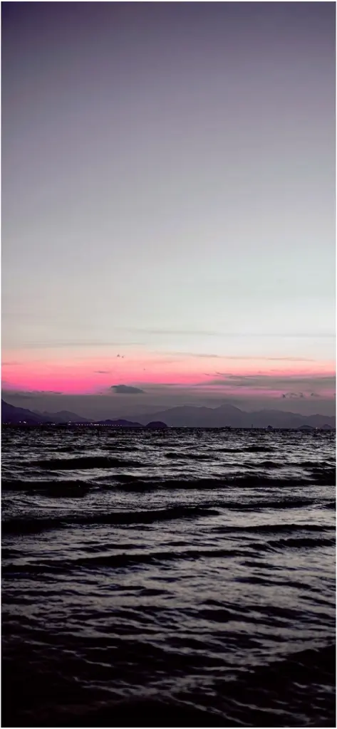 ruhiger sonnenuntergang ueber dunklem gewaesser