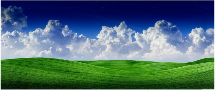 sanfte gruene huegel unter blauem himmel mit wolken