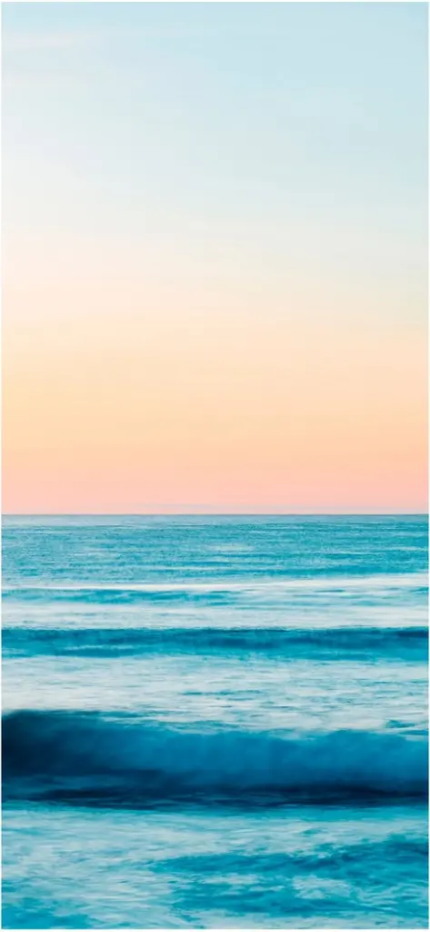 sanfte wellen und pastellhimmel ueber dem meer