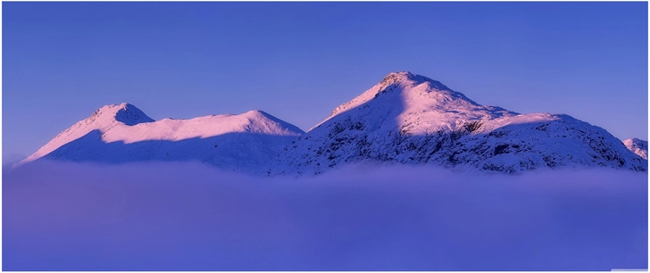schneebedeckte berge im winternebel mit blauem himmel
