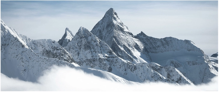 schneebedeckte berge ueber den wolken