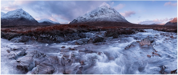 schneebedeckte berge und fluss im tal