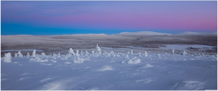 schneebedeckte winterlandschaft mit farbigem himmel