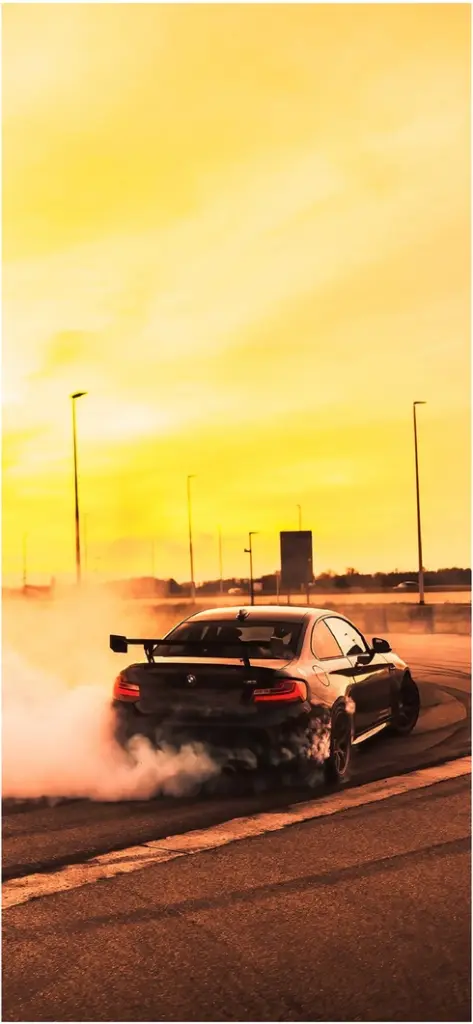 schwarzer bmw driftet bei sonnenuntergang auf strasse
