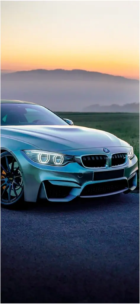 silberner bmw auf asphaltstrasse bei sonnenuntergang