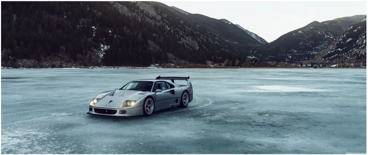 silbernes sportauto auf gefrorenem see winterlandschaft
