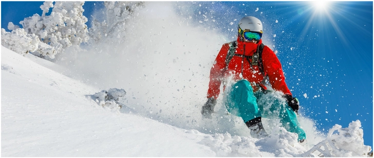 skifahrer im frischen schnee bei strahlendem himmel
