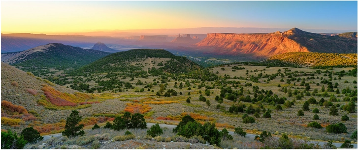sonnenuntergang ueber huegelige landschaft in utah