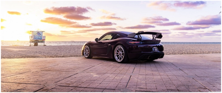 sportwagen am strand mit sonnenuntergang
