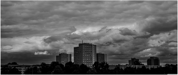 stadtlandschaft mit hohen gebaeuden und dramatischem himmel