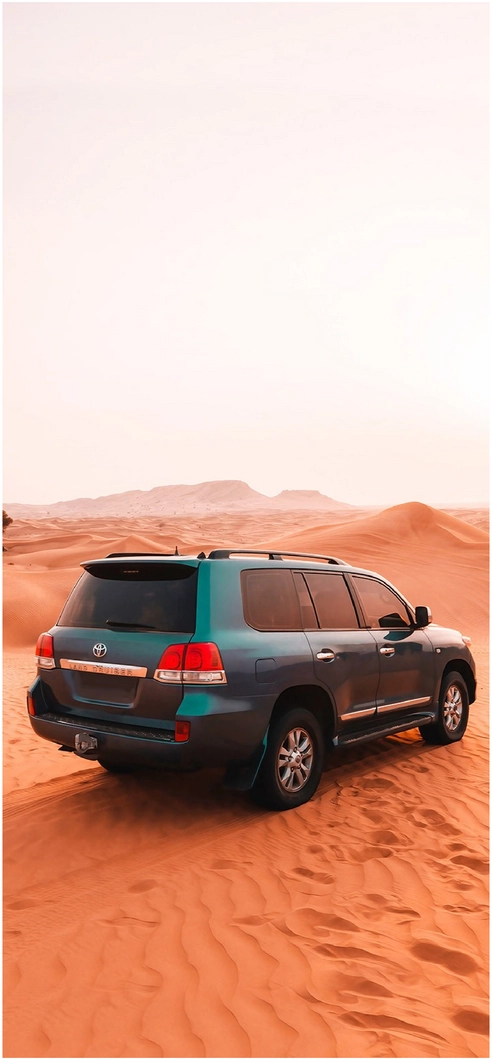 suv-in-der-wueste-mit-sandduenen-im-hintergrund