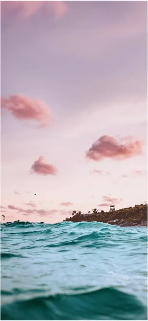 tuerkisfarbenes wasser und rosa himmel ueber dem meer