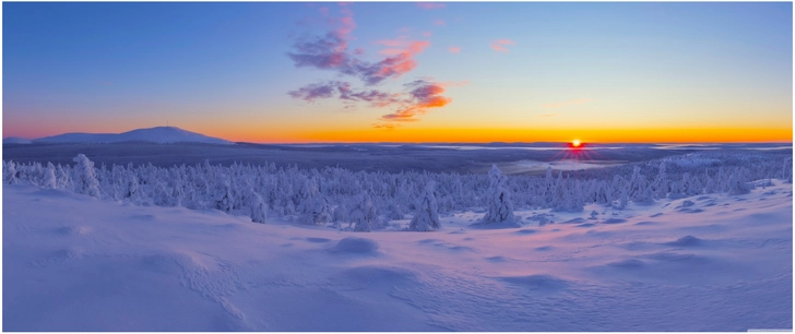 verschneite winterlandschaft mit sonnenuntergang