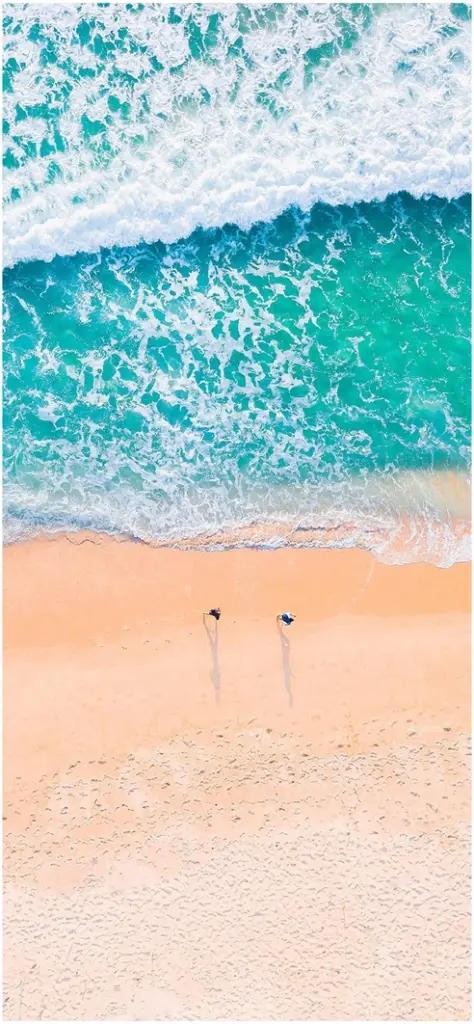 vogelperspektive auf strand und tuerkisfarbenes wasser