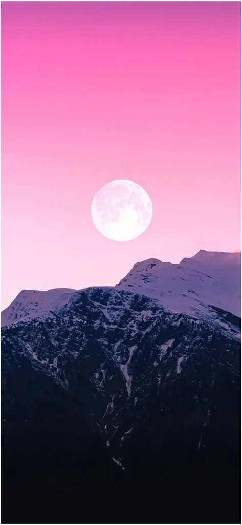 vollmond ueber schneebedeckten bergen im rosa himmel