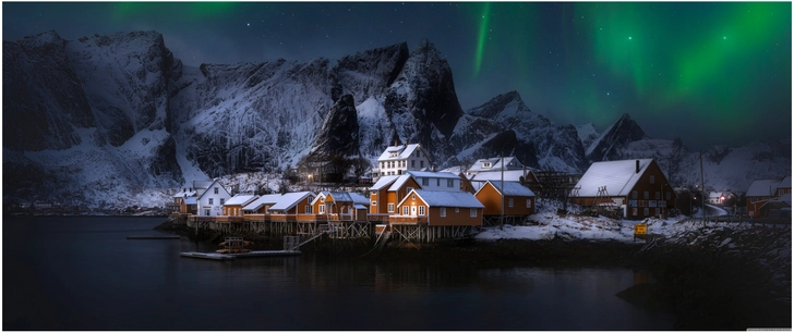 winterlandschaft mit aurora borealis und holzhaeusern